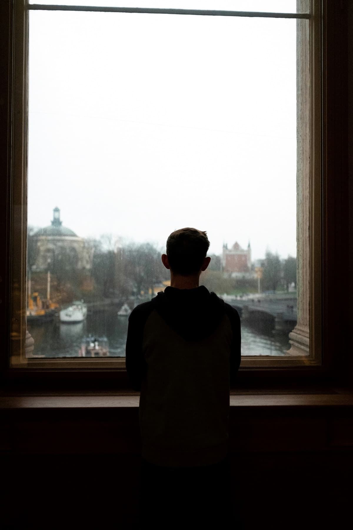 Man looking out window reflecting on mental health journey